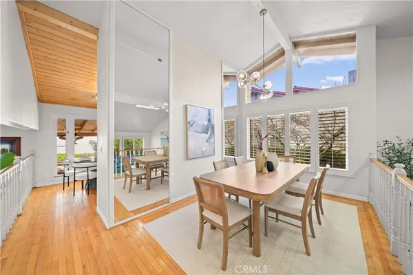 a dining room with furniture large windows and wooden floor