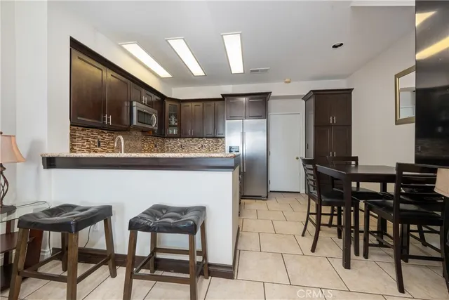 a kitchen with stainless steel appliances kitchen island granite countertop a table and chairs in it