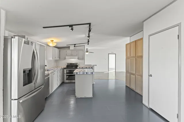 a kitchen with refrigerator and cabinets