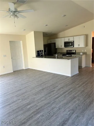 a view of kitchen with stainless steel appliances refrigerator stove microwave and cabinets