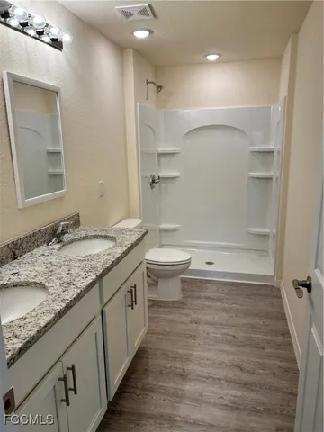 a bathroom with a granite countertop sink toilet and shower