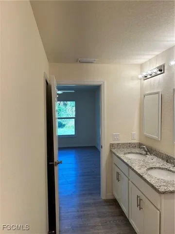 a bathroom with a granite countertop sink and mirror