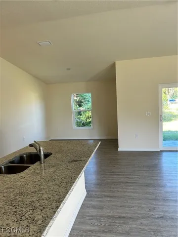 a view of a livingroom with wooden floor and a rug