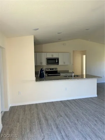 a view of a refrigerator in kitchen and wooden floor