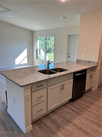 a kitchen with granite countertop kitchen island white cabinets granite counter tops and a window