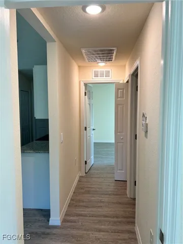 a view of a hallway with wooden floor