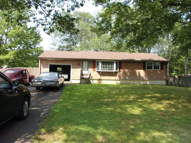 a front view of a house with a garden and trees