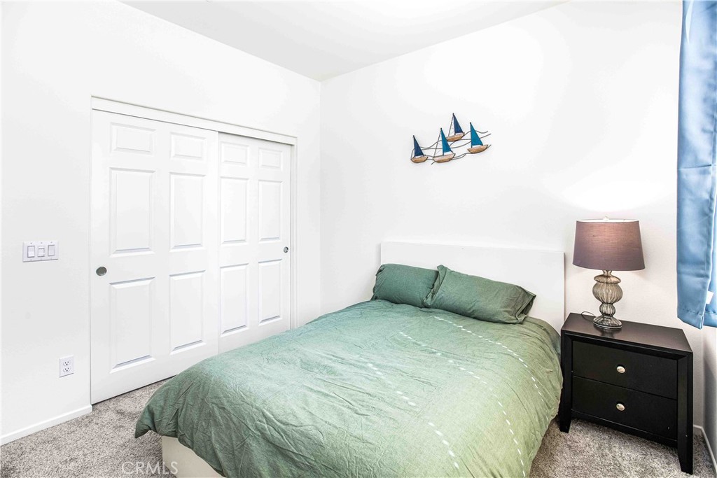 14563 Gulfstream Lane Moreno Valley, CA 92553 - Photo 14 of 30 a bedroom with a bed and a night stand