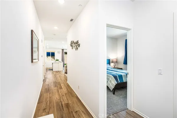 a view of a hallway with a livingroom and a kitchen