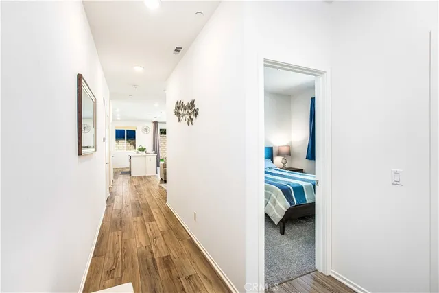 a view of a hallway with a livingroom and a kitchen