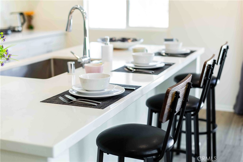 14563 Gulfstream Lane Moreno Valley, CA 92553 - Photo 9 of 30 a kitchen with a dining table chairs and stove