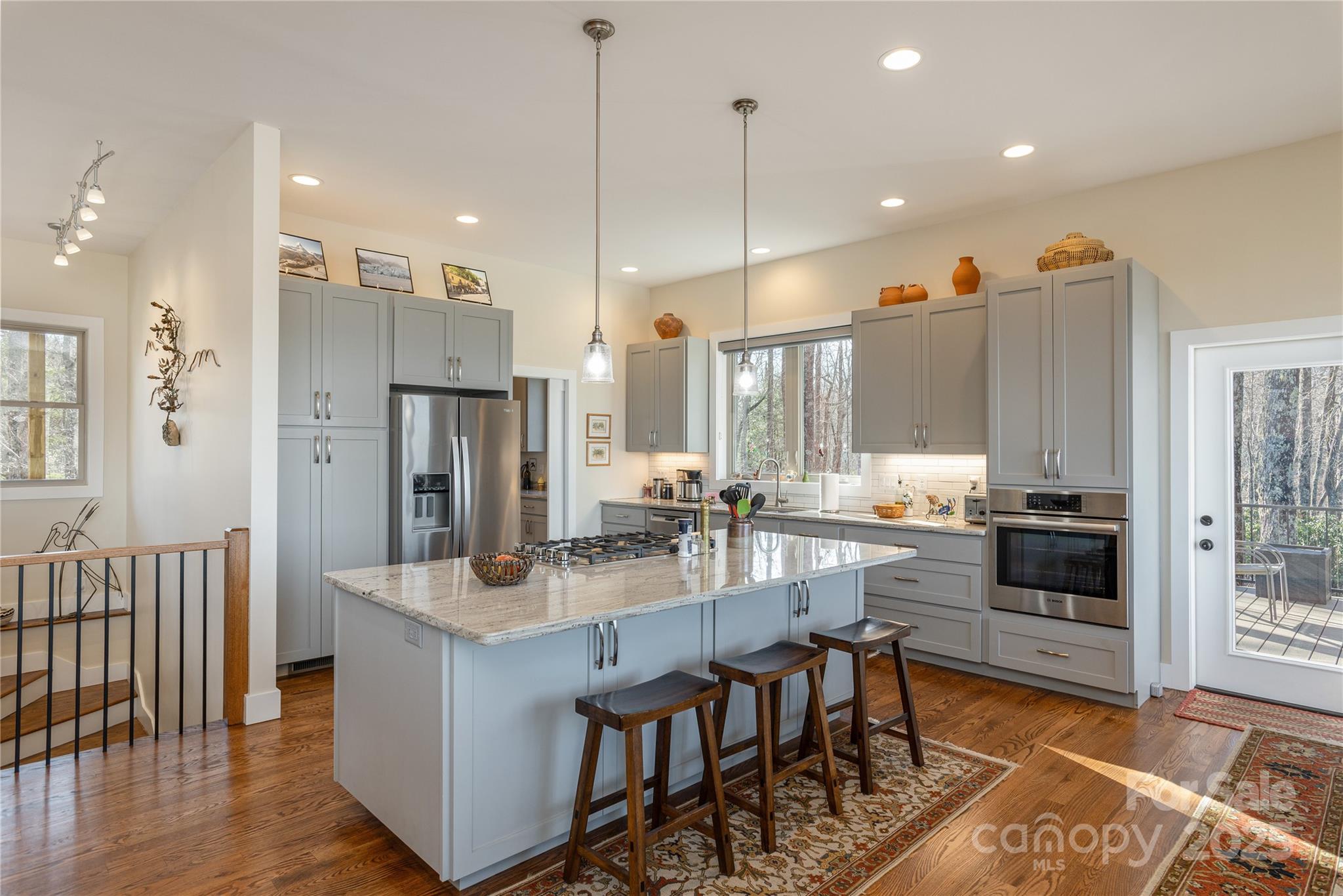 69 Pepperbush Road Brevard, NC 28712 - Photo 7 of 34 a kitchen with stainless steel appliances kitchen island granite countertop a stove a refrigerator a oven and white cabinets with wooden floor