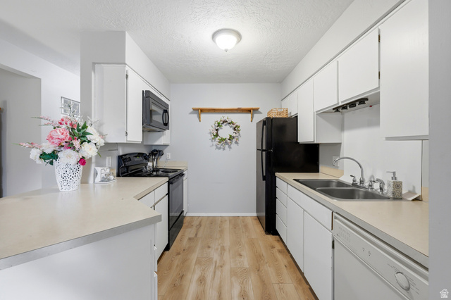 1175 Canyon Road, Unit 86 Ogden, UT 84404 - Photo 11 of 29 Bright kitchen featuring white cabinetry, light-toned countertops, wood-finish flooring, a double basin stainless steel sink, and a full suite of black appliances