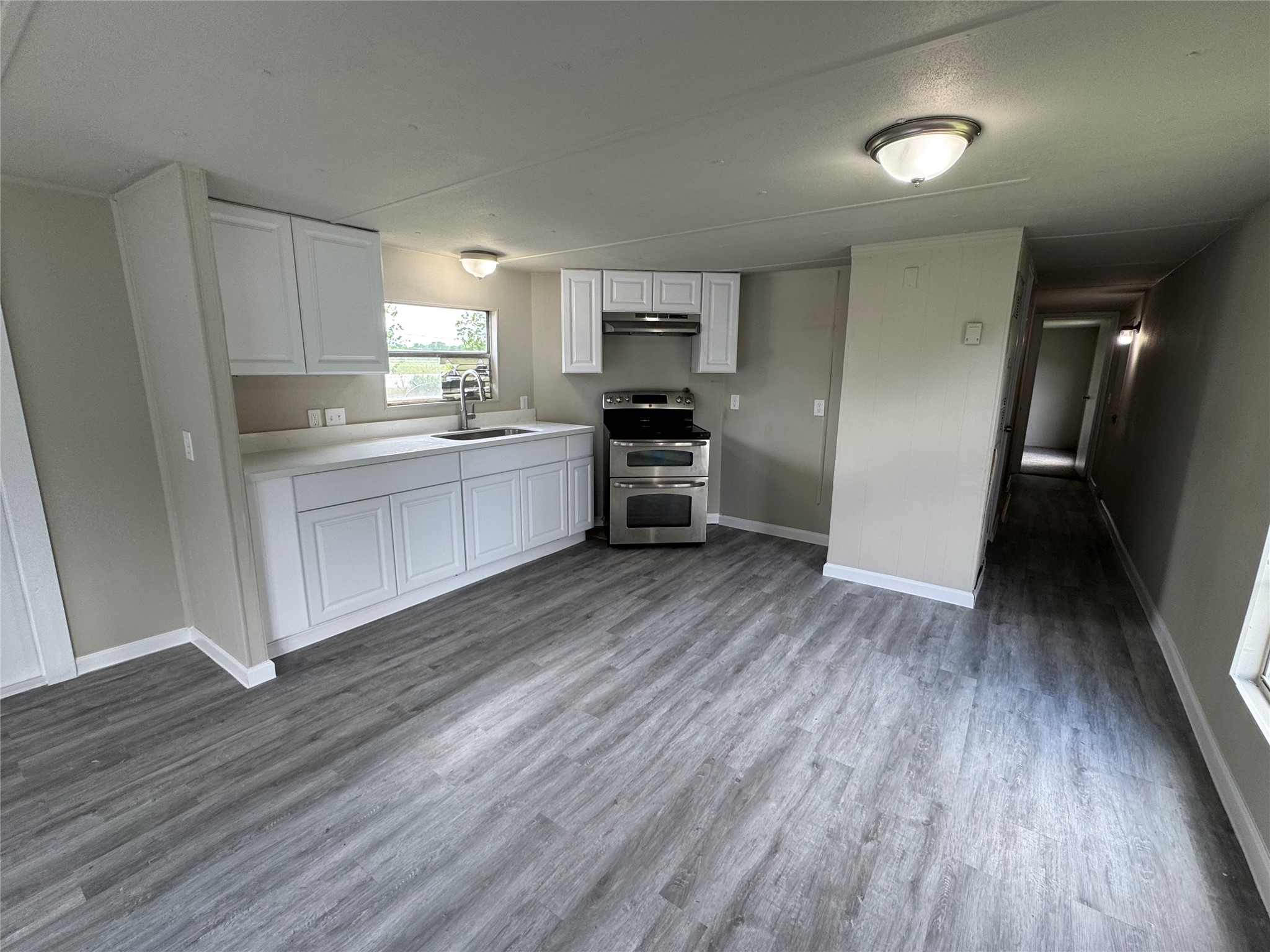 6226 County Road 48 Rosharon, TX 77583 - Photo 3 of 11 a kitchen with a hard wood floor white cabinets and stainless steel appliances