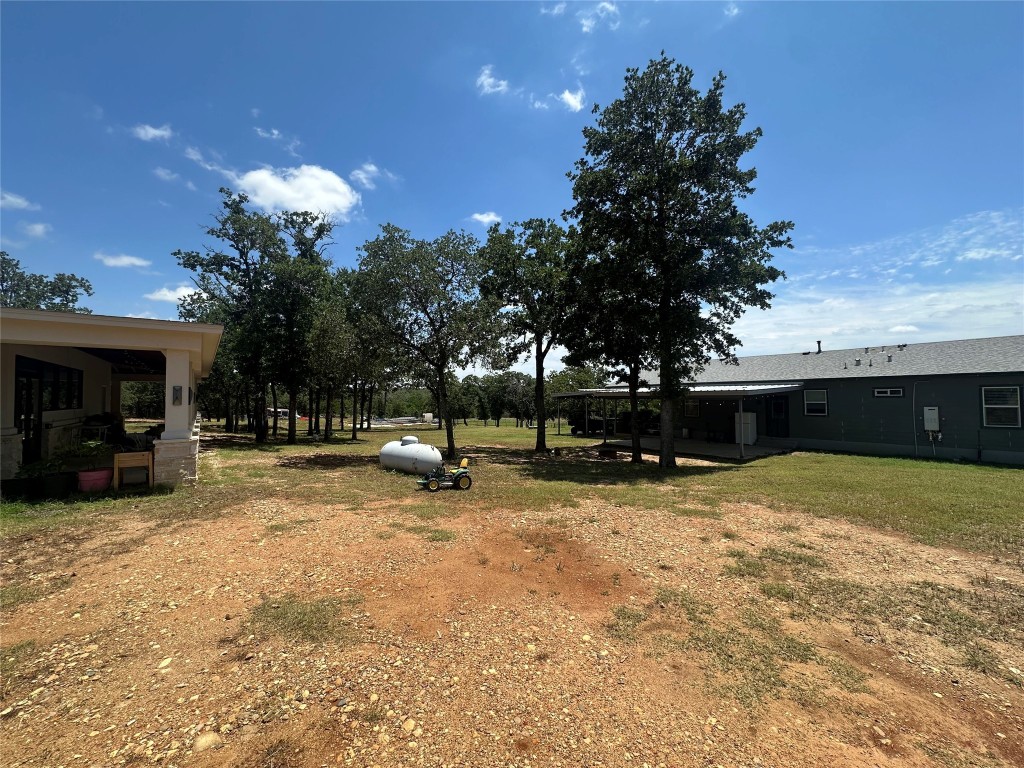 1231 Oak Grove Road Luling, TX 78648 - Photo 5 of 40 a view of a house with a backyard and a tree