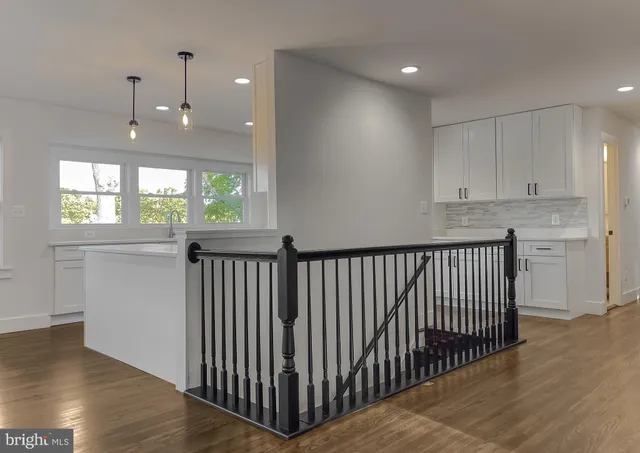 a kitchen with stainless steel appliances a white stove top oven cabinets and a wooden floor