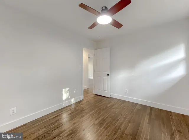 a view of a brick house with a small yard and wooden fence