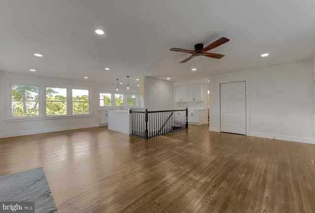 a kitchen with stainless steel appliances granite countertop a refrigerator a sink dishwasher a stove and a dining table with wooden floor