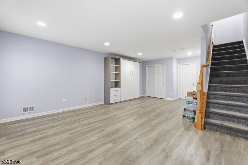 335 Wilshire Drive Nutley, NJ 07110 - Photo 16 of 23 an empty room with wooden floor and stairs
