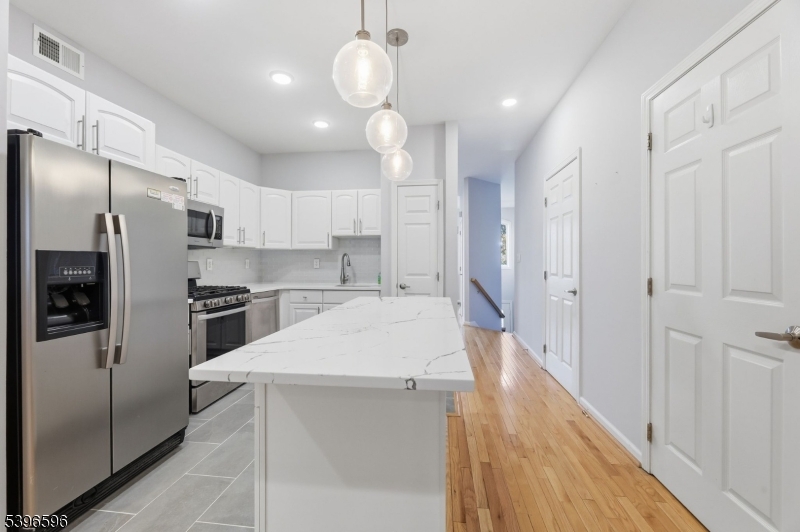 335 Wilshire Drive Nutley, NJ 07110 - Photo 4 of 23 a large kitchen with white cabinets stainless steel appliances