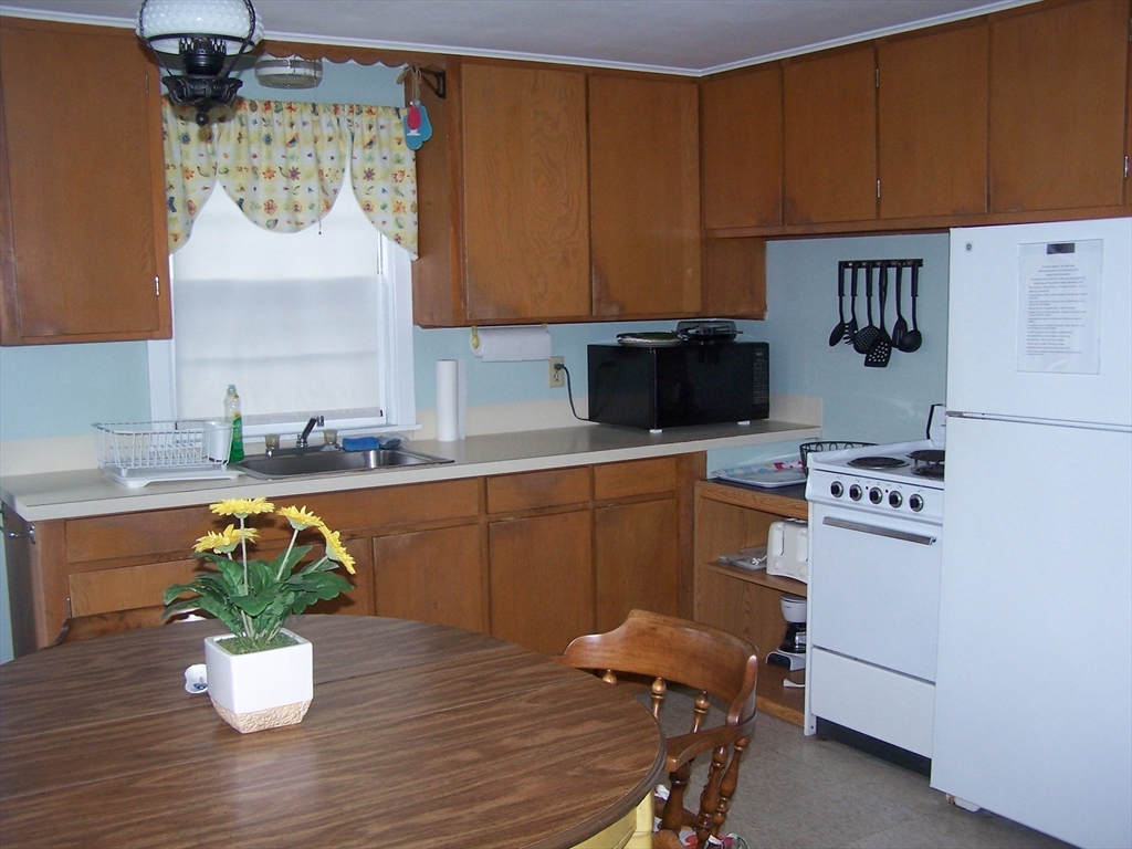 334 Phillips Sagamore Beach, MA 02562 - Photo 3 of 5 a kitchen with a refrigerator and a stove top oven