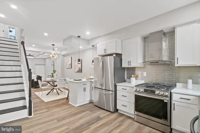 a kitchen with white cabinets and stainless steel appliances