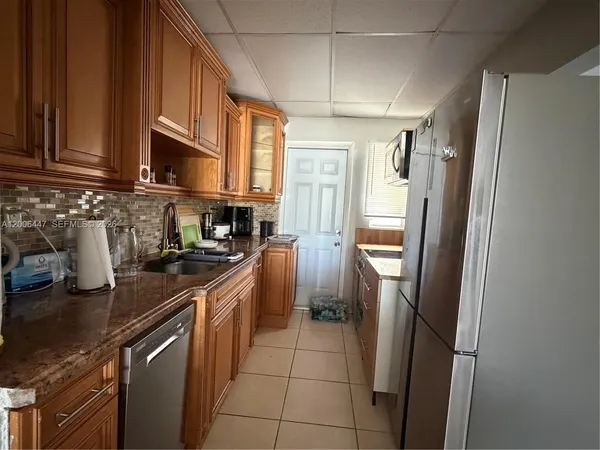 a kitchen with stainless steel appliances granite countertop a refrigerator a sink a stove and dishwasher