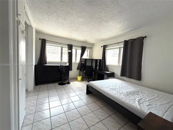 a large bedroom with a bed and a dresser in it