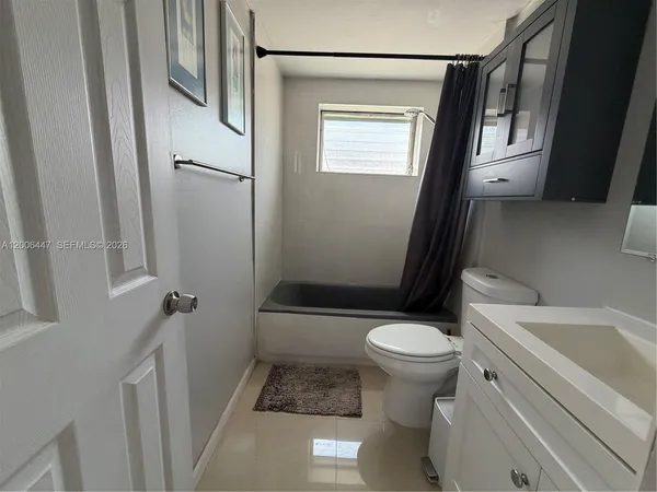 a white toilet sitting next to a bathroom sink and a tub
