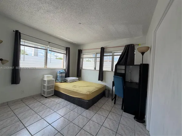 a bedroom with a bed and large windows
