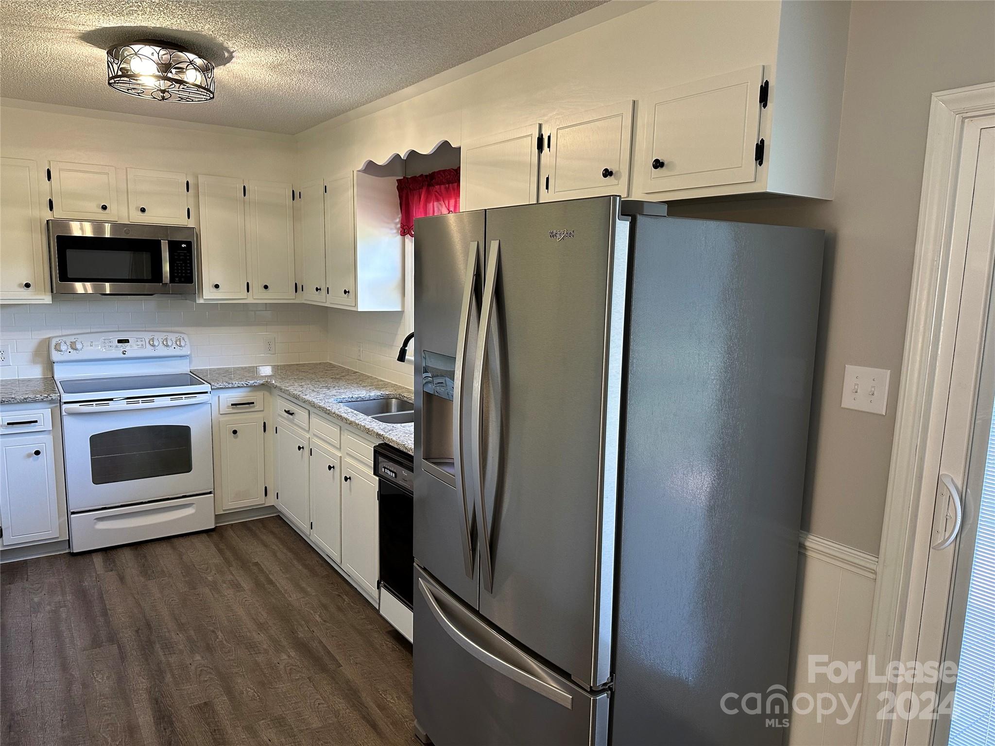 147 Sinclair Road Mooresville, NC 28115 - Photo 3 of 21 a kitchen with granite countertop a refrigerator stove and sink