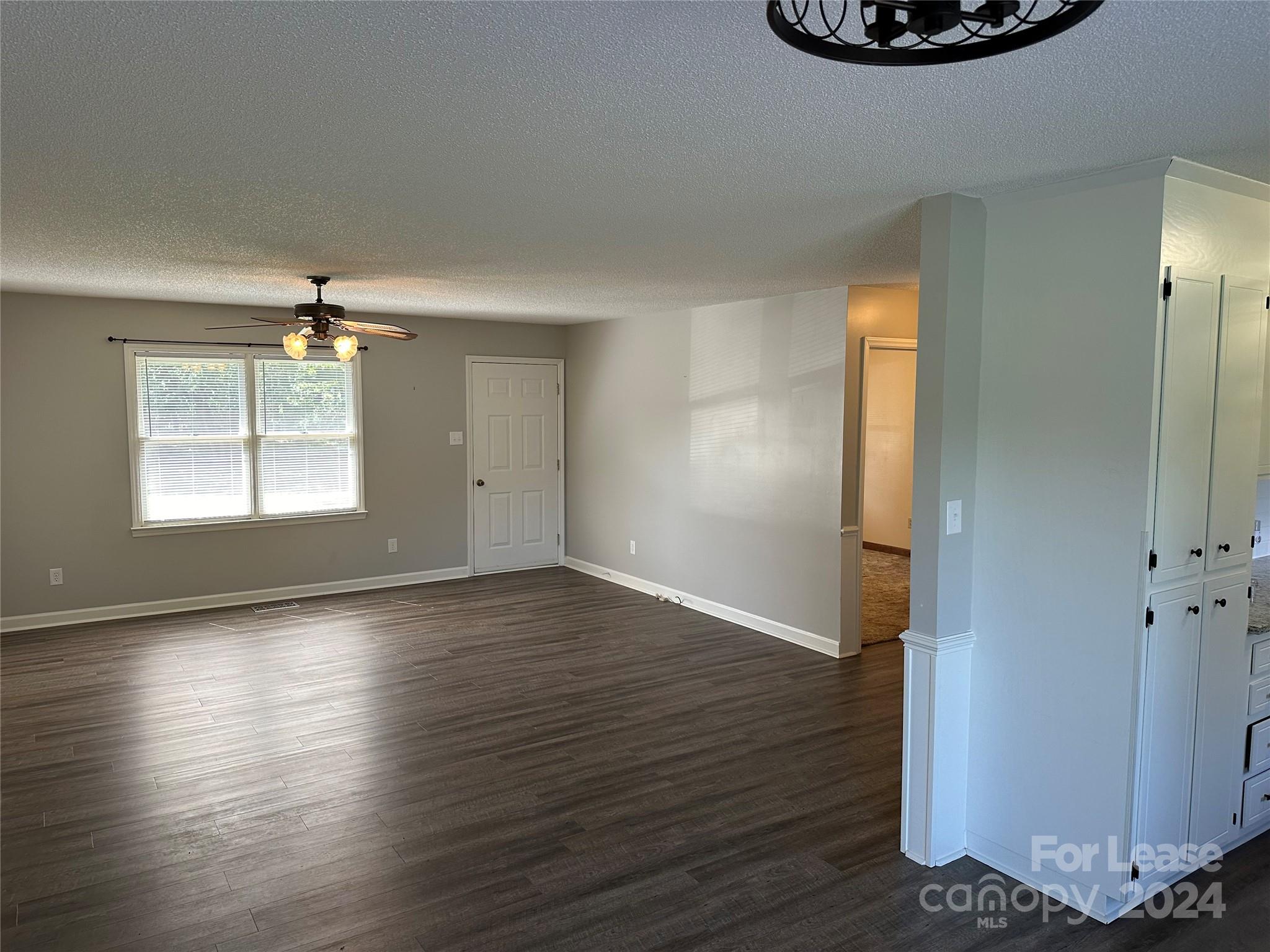 147 Sinclair Road Mooresville, NC 28115 - Photo 5 of 21 an empty room with wooden floor cabinet and windows