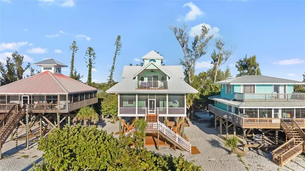 an aerial view of a house with swimming pool and large trees