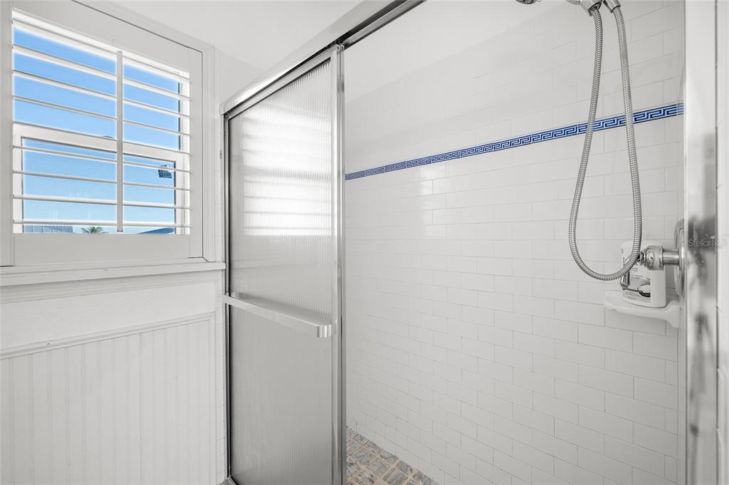 8798 Grand Avenue Boca Grande, FL 33921 - Photo 36 of 64 a bathroom with a glass shower door