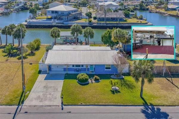 an aerial view of a house with swimming pool lawn chairs and lake view