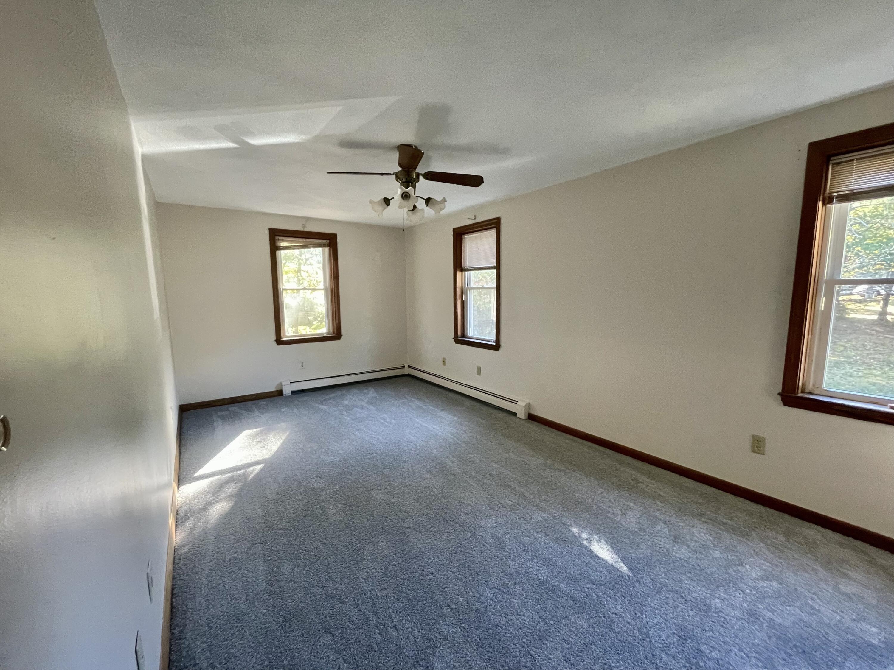 103 Clay Pond Road Bourne, MA 02532 - Photo 8 of 26 an empty room with windows and ceiling fan