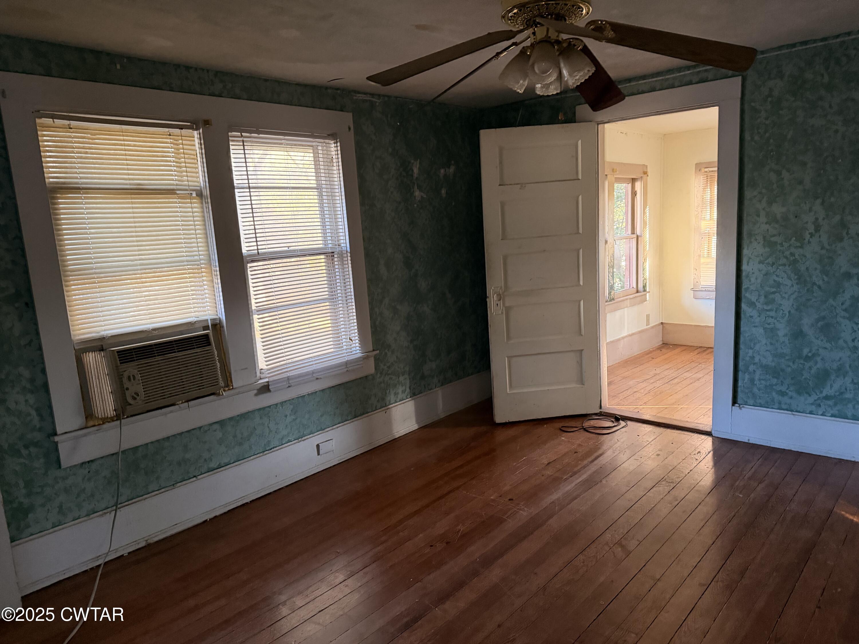 400 West Grand Street Jackson, TN 38301 - Photo 10 of 13 an empty room with wooden floor cabinet and windows