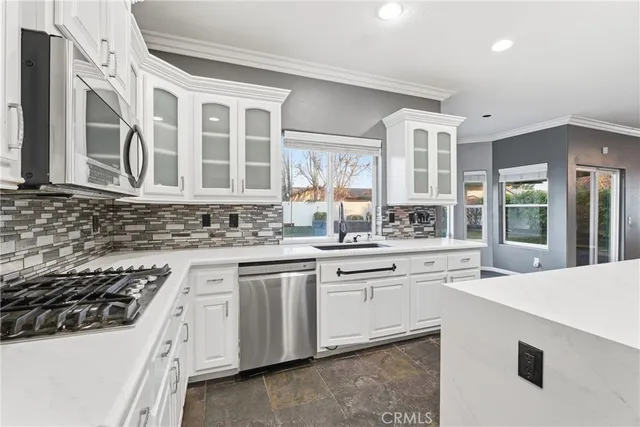 a kitchen with granite countertop a sink stove and cabinets