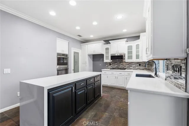 a kitchen with stainless steel appliances kitchen island granite countertop a sink and cabinets