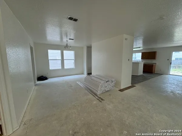 an empty room with windows and cabinet