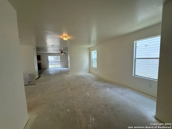 a view of empty room with windows and fireplace