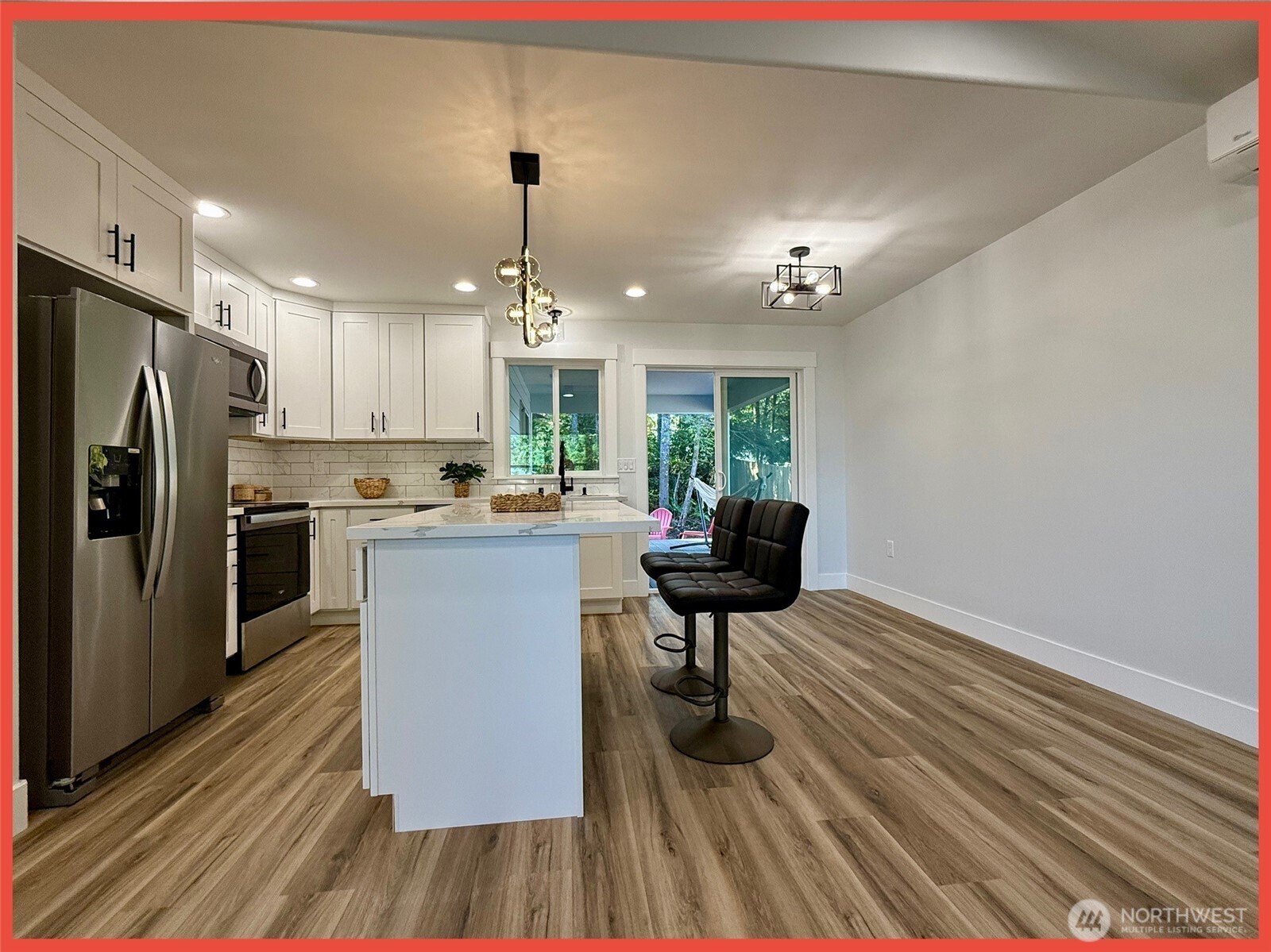 611 Weatherwax Loop Northeast Ocean Shores, WA 98569 - Photo 25 of 39 a kitchen with stainless steel appliances a dining table chairs stove and refrigerator