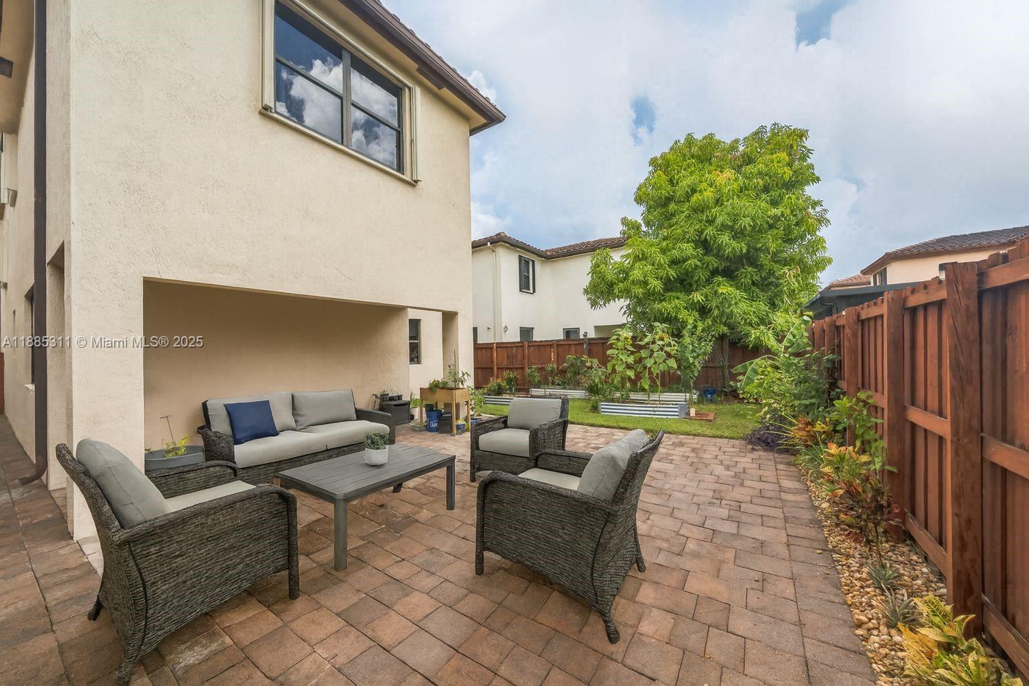 627 Southeast 34th Avenue Homestead, FL 33033 - Photo 1 of 17 a patio with patio a couch and potted plants