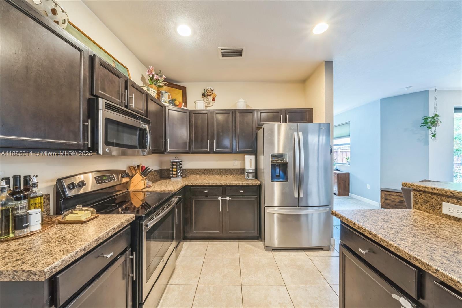 627 Southeast 34th Avenue Homestead, FL 33033 - Photo 4 of 17 a kitchen with stainless steel appliances granite countertop a sink stove and refrigerator