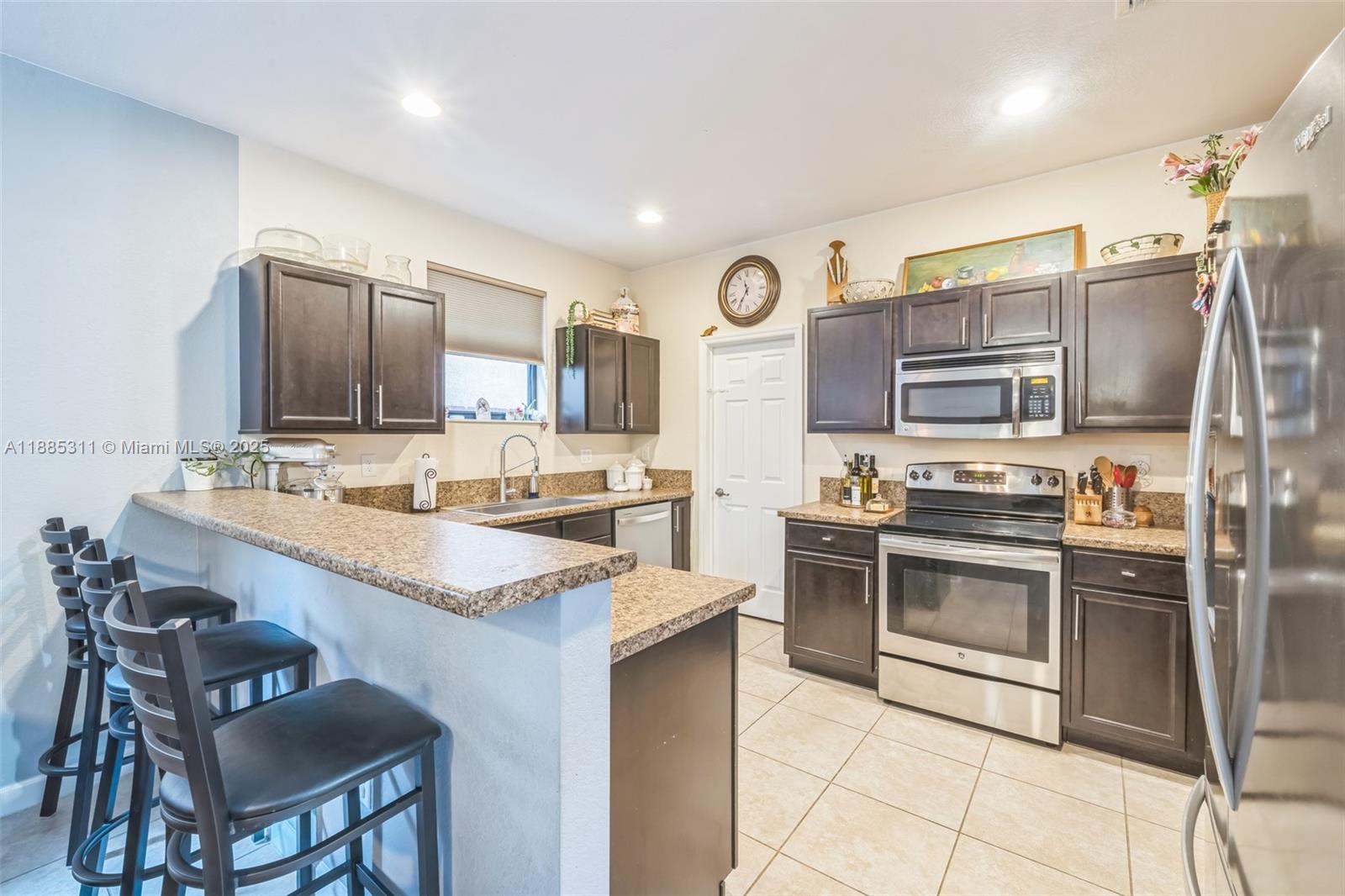 627 Southeast 34th Avenue Homestead, FL 33033 - Photo 5 of 17 a kitchen with stainless steel appliances granite countertop a stove top oven a sink and a refrigerator