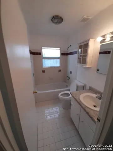 a bathroom with a granite countertop sink a mirror and a bathtub