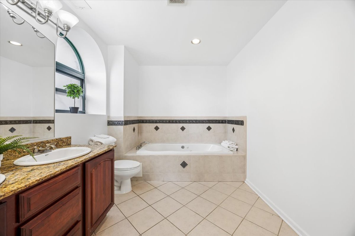 2363 East 70th Street, Unit 1 Chicago, IL 60649 - Photo 20 of 26 a spacious bathroom with a granite countertop sink and a mirror
