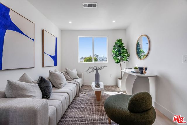 a living room with furniture a lamp and a potted plant
