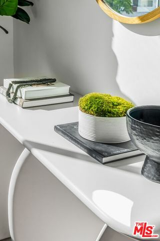a white and white vase of flowers sitting on a floor