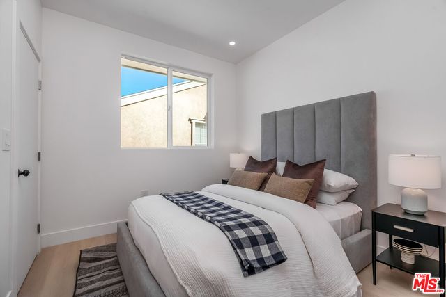 a bedroom with a bed and a lamp on dresser